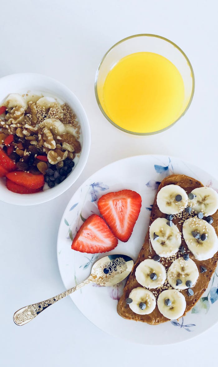 services-01 Nutritious breakfast with banana toast, fruit bowl, and orange juice, perfect for a healthy start.